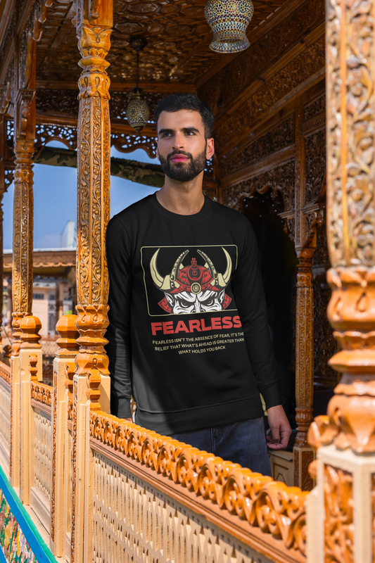 Man wearing a black sweatshirt with a graphic design and text, standing in front of ornate wooden architecture.